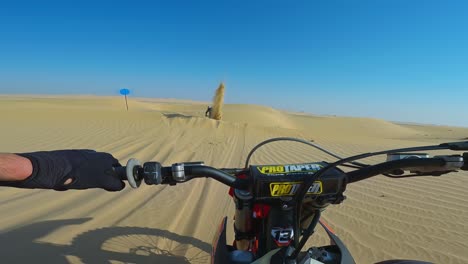 Rider-navigating-through-dunes-kicking-up-sand-dust,-fast-paced-action