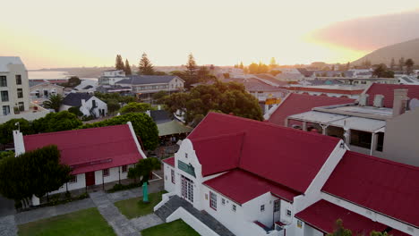 Iconic-Whale-Museum-and-De-Wet's-Huis-Photo-Museum-in-Hermanus,-sunset-aerial