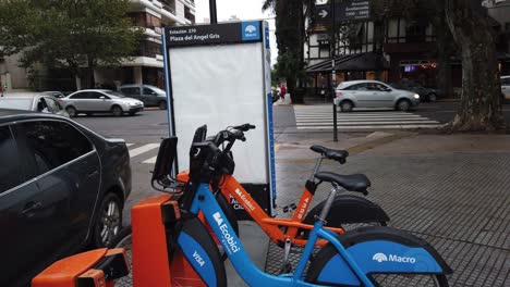 Public-bicycle-transport-service-parked-at-urban-green-station-park-buenos-aires-city-argentina-traffic-in-gaona-avenue,-caballito-in-wet-humid-autumn-daylight