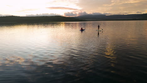Drone-Flyback-Couple-On-Paddleboard-And-Kayak-At-Sunrise-In-Moso-Island,-North-Efate,-Vanuatu