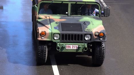 Camouflage-military-vehicle-driving-down-the-street-during-the-annual-Anzac-Day-parade-tradition-at-Brisbane-city,-close-up-shot