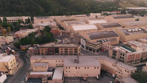 Aerial-Drone-Footage-of-Warner-Brother's-Backlot-in-Daytime,-New-York-Street-Set-and-Fake-Neighborhoods,-Soundstages-with-Green-Mountains-in-Background