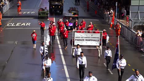 Anzac-Day-Parade-Committee,-Parade-Marshalls-walking-down-the-street-of-Brisbane-city