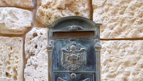 Antiguo-Buzón-Medieval-En-Fachada-De-Piedra-Arenisca-De-Un-Edificio-Histórico-En-Mdina,-Malta