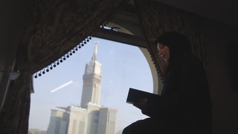 Veiled-woman-praying-with-the-backdrop-of-the-awe-inspiring-Abraj-Al-Bait