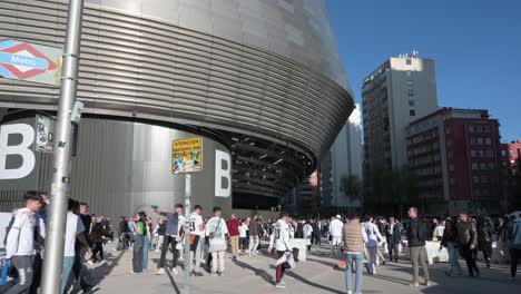 Se-Ve-Una-Toma-De-Gran-Angular-De-Aficionados-Al-Fútbol-Fuera-Del-Estadio-Santiago-Bernabéu-Del-Real-Madrid-Mientras-Asisten-Al-Partido-De-Fútbol-De-La-Liga-De-Campeones-Contra-El-Equipo-De-Fútbol-Británico-Manchester-City-Club.