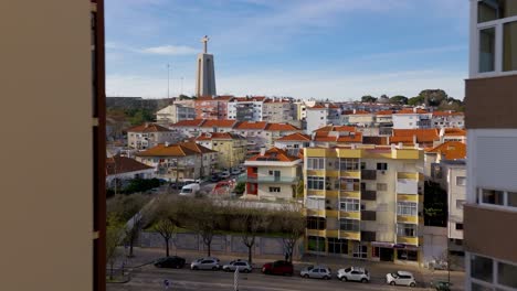 Cristo-Rei-discovered-behind-high-buildings-cityscape