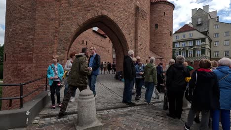 Entrance-of-the-historic-Warsaw-Barbican,-a-significant-landmark-in-Poland,-people-embrace-the-concept-of-travel-and-exploration-as-they-delve-into-its-rich-history-and-architectural-marvels