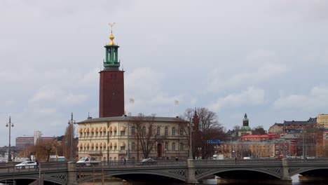 Stockholmer-Rathausturm-Mit-Bewölktem-Himmel,-Brücke-Im-Vordergrund,-Ruhiges-Stadtbild