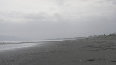 Hand-held-shot-of-a-couple-walking-down-a-beach-on-Canas-island