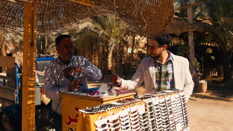 Tourist-bargain-with-souvenir-merchant-seller-in-Siwa-oasis,-Egypt