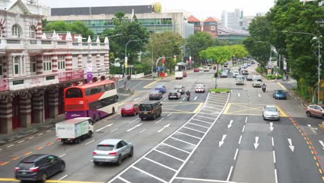 Toma-De-Lapso-De-Tiempo-Del-Tráfico-De-Vehículos-Intensos-En-La-Intersección-Entre-Hill-Street-Y-Coleman-Street-En-El-Centro-De-Singapur,-Autobuses-Y-Automóviles-Que-Circulan-Por-La-Carretera-En-Un-Día-Lluvioso-En-El-Centro-De-La-Ciudad