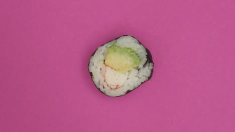 Sushi-roll-rotating-on-pink-background