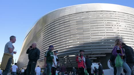 Toma-De-ángulo-Bajo-De-Aficionados-Al-Fútbol-Que-Llegan-Al-Estadio-Santiago-Bernabéu-Del-Real-Madrid-Mientras-Asisten-Al-Partido-De-Fútbol-De-La-Liga-De-Campeones-Contra-El-Equipo-De-Fútbol-Británico-Manchester-City-Club.