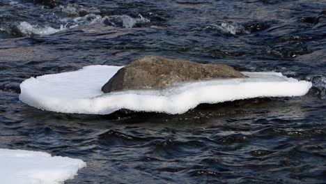 Fluss,-Der-Im-Frühjahr-Im-Süden-Islands-An-Einem-Schneebedeckten-Felsen-Vorbeifließt