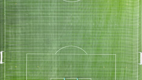 An-aerial-view-of-a-neatly-maintained-soccer-field-with-visible-white-boundary-lines-and-goalposts-at-each-end