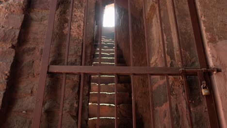 Locked-iron-gate-with-light-streaming-through-at-Dadi-Poti-Tombs,-Hauz-Khas,-New-Dehli