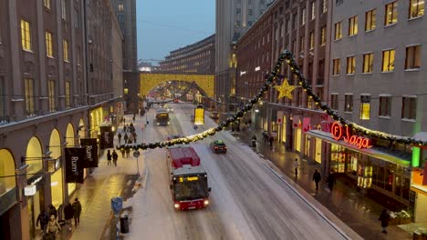 Kungsgatan-street-in-downtown-Stockholm-with-Christmas-decorations-during-snowfall