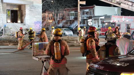 Feuerwehrleute-In-Der-Nacht-Nach-Einem-Brand-In-Einem-Verlassenen-Gebäude-In-Montreal,-Einsatzfahrzeuge-Und-Lichter-Sichtbar