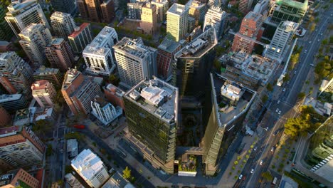 Aerial-tilt-down-view-of-MUT-towers,-modern-buildings-in-Santiago-bustling-touristic-Place,-Chile