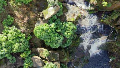 Aerial-drone-footage-of-a-tall-rocky-waterfall-in-the-Yorkshire-Dales,-Pennies