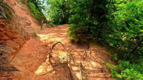 Walk-inside-earth-path-landscape-Cliff-rock-walkway,-Erglu-Cliffs-Klintis-Latvia-first-person-POV-shot-around-trees,-hiking-hill-at-Gauja-National-Park