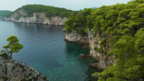 Isla-Kalamota,-Mar-Adriático,-Croacia---Aguas-Cristalinas-Que-Contrastan-Con-Una-Costa-Escarpada---Drones-Volando-Hacia-Adelante