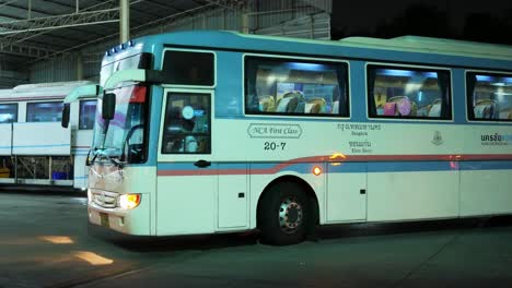 Sitting-on-the-bus,-the-driver-turned-on-the-hazard-lights-to-warn-the-passersby-at-a-bus-station-in-Bangkok,-Thailand