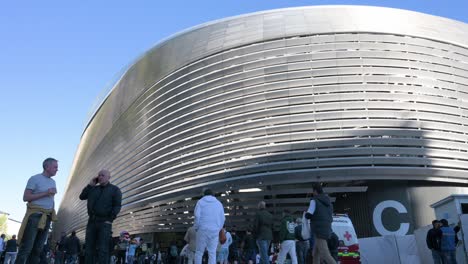 Low-angle-view-shot-of-fans-arriving-at-Real-Madrid´s-Santiago-Bernabeu-stadium-attending-the-Champions-League-match-between-Spanish-and-British-football-teams-Real-Madrid-and-Manchester-City-club