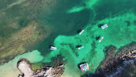 Drone-perspective,-parade-of-boats-and-yachts-at-Playa-La-Entrega,-Huatulco,-Oaxaca