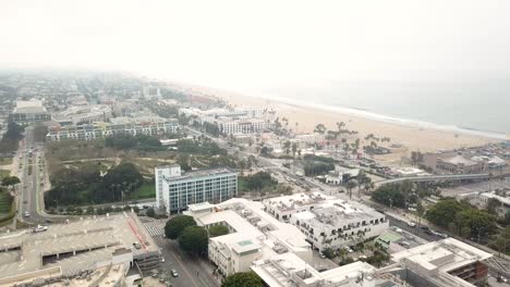 Drone-Shot-of-Santa-Monica-Pier-on-the-Pacific-Ocean-in-Santa-Monica,-California-on-a-Cloudy-day