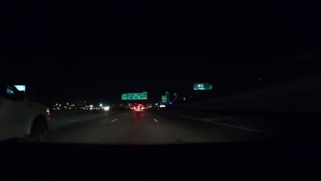 Hiperlapso-Número-Dos-De-La-Serie-Que-Muestra-Un-Automóvil-Conduciendo-Por-La-Interestatal-Hacia-Dallas,-Texas,-Por-La-Noche-Con-Las-Luces-De-La-Ciudad-Y-Las-Luces-Del-Edificio-Del-Centro-Al-Fondo