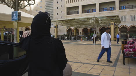 Mujer-Musulmana-Con-Aplomo-Y-Extravagancia-Descendiendo-De-Un-Automóvil-Y-Entrando-Al-Hotel-Anjum-Makkah.