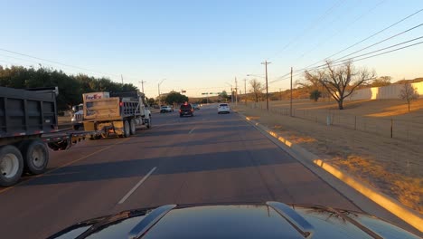 Conducción-De-Automóviles-Al-Atardecer-A-Través-De-Fredericksburg,-Texas,-Estados-Unidos,-Toma-Amplia-Pov