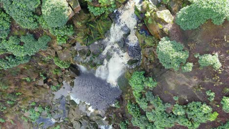 Aerial-drone-footage-of-a-tall-rocky-waterfall-in-the-Yorkshire-Dales,-Pennies