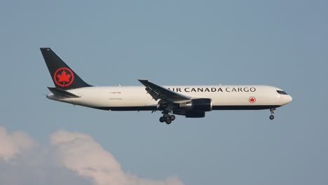 Air-Canada-cargo-plane-mid-flight-against-blue-sky,-clear-day,-side-view