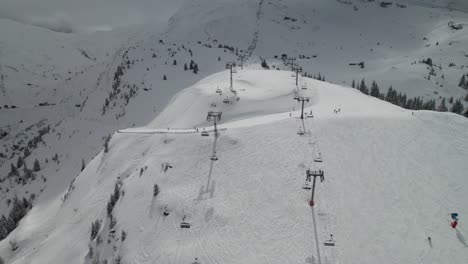 Belebtes-Skigebiet-In-Den-Alpen,-Sessellifte-Und-Skifahrer,-4k-Drohnenaufnahme