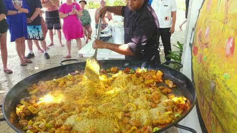 Chef-stirs-rice-into-Papaya-mixture-of-fish,-shrimp,-and-muscles-at-Impressive-Resort-and-Spa-in-Punta-Cana,-Dominican-Republic