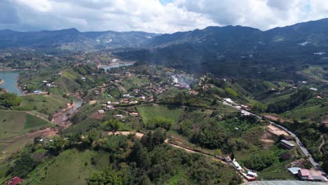 Aerial-View,-Picturesque-Landscape-of-Guatape-Region-in-Colombia,-Green-Hills,-Village-Roads-and-Lake