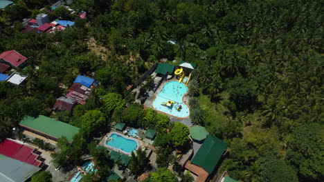 Aerial-view-around-a-waterpark-resort-in-sunny-Province-of-Laguna,-Philippines