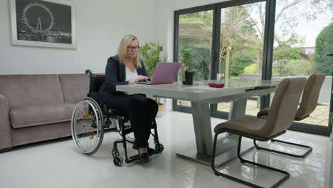 Woman-in-wheelchair-working-in-home-office-right-to-left-camera-move
