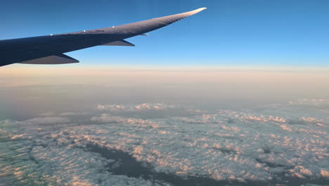 Panoramic-view-from-flying-plane-window-above-clouds