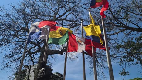 Cali,-Colombia,-Flags-Waving-Above-Simon-Bolivar-Sculpture-in-Downtown-Park-on-Sunny-Day