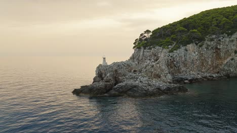 Kalamota-Island,-Adriatic-Sea,-Croatia---The-View-of-a-Lighthouse-Resting-Atop-a-Rugged-Cliff---Aerial-Drone-Shot