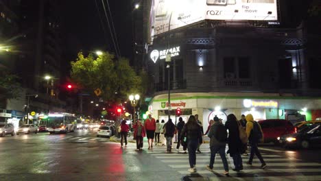 La-Gente-Camina-En-La-Vibrante-Ciudad-Metropolitana-De-Buenos-Aires-En-América-Latina,-El-Tráfico-Pasa-Por-Una-Zona-Asfaltada-Con-Carteles-Comerciales-Y-Tiendas.