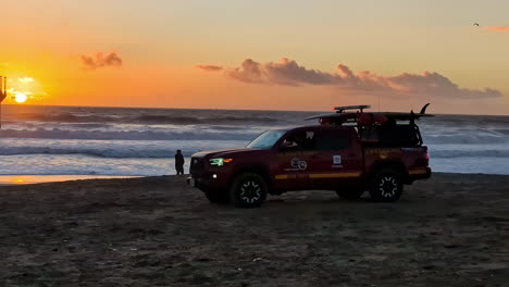 Lifeguard-truck-watching-people-swim-in-the-Pacific-Ocean-in-Manhattan-Beach,-Los-Angeles