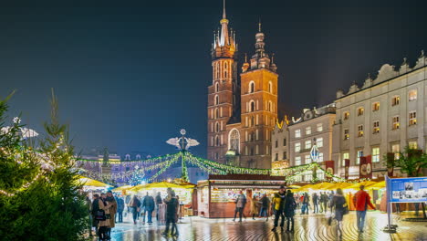 Timelapse-De-Puestos-Navideños-Por-La-Noche-En-La-Plaza-Principal-Del-Mercado-De-Cracovia,-Polonia---Movimiento-Lento,-Acercar