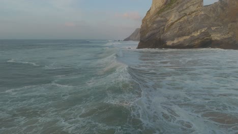 Ocean-wave-crushing-on-remote-cliffs-at-sunset