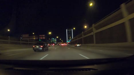 Series-number-six-hyperlapse-showing-car-driving-through-downtown-Dallas-Texas-at-night-with-city-lights,-stop-lights,-interstate-driving,-and-high-rise-towers