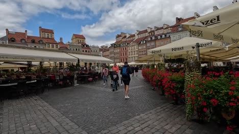 Strolling-through-the-quaint-coffee-shops-and-bustling-square-of-Warsaw's-Old-Town-Market-Place,-the-heart-and-oldest-section-of-Warsaw's-historic-Old-Town-in-Poland